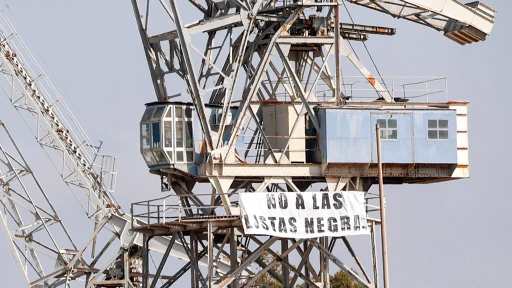 Pancarta contra las listas negras desplegada en una grúa de la empresa Navantia